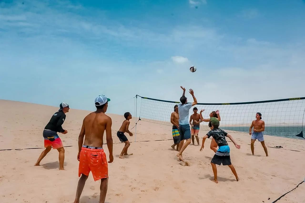 Groupe jouant au beach-volley entre le lagon et les dunes de Dakhla