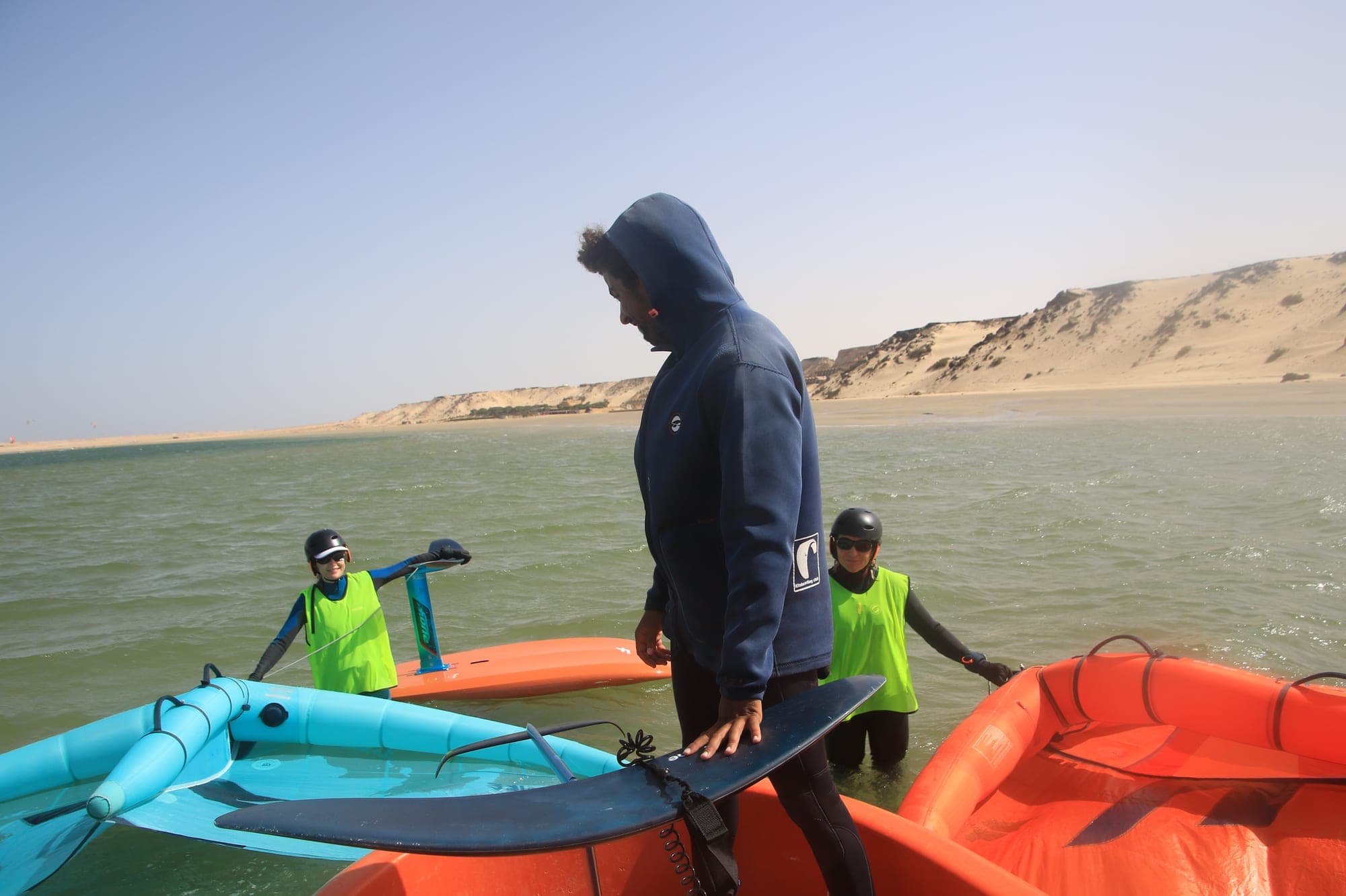 Moniteur préparant une session de wingfoil avec deux élèves dans le lagon de Dakhla
