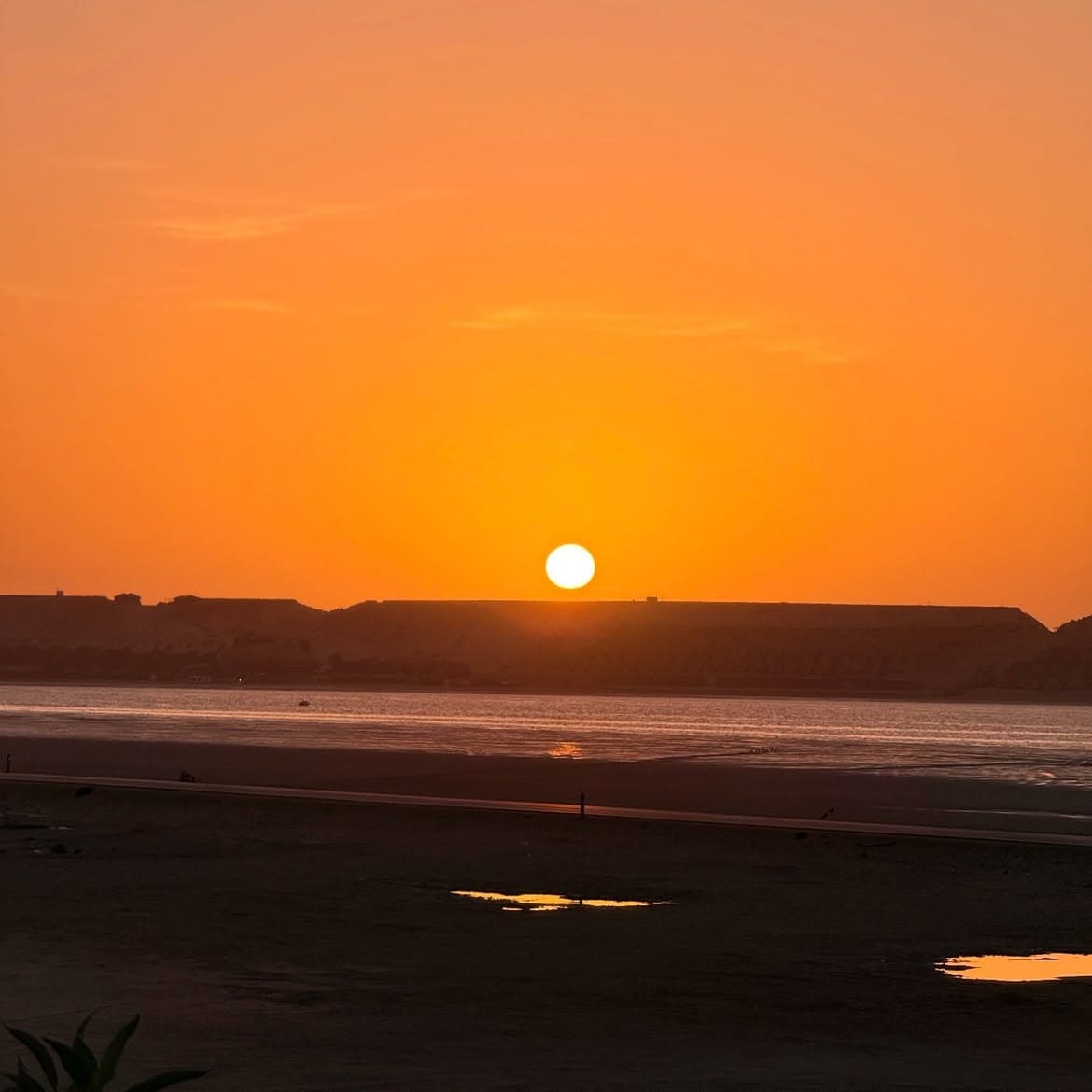 Soleil couchant orange au-dessus du lagon et des dunes de Dakhla