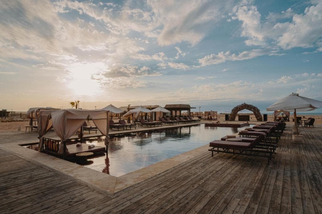 Piscine entourée de transats et de cabanes au MIA Resort à Dakhla